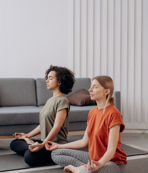 Person in a calm, flowing yoga-like pose in a minimalist room.